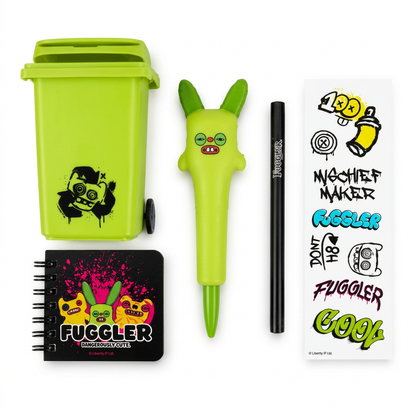 A Fuggler brand novelty set featuring a bright lime green trash can, a matching lime green bunny-shaped marker pen, a black marker, a black notebook with colorful graffiti-style artwork, and a sheet of temporary tattoos with matching designs, all arranged on a clean white background.